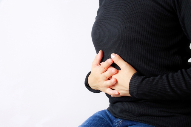 お腹を押える女性